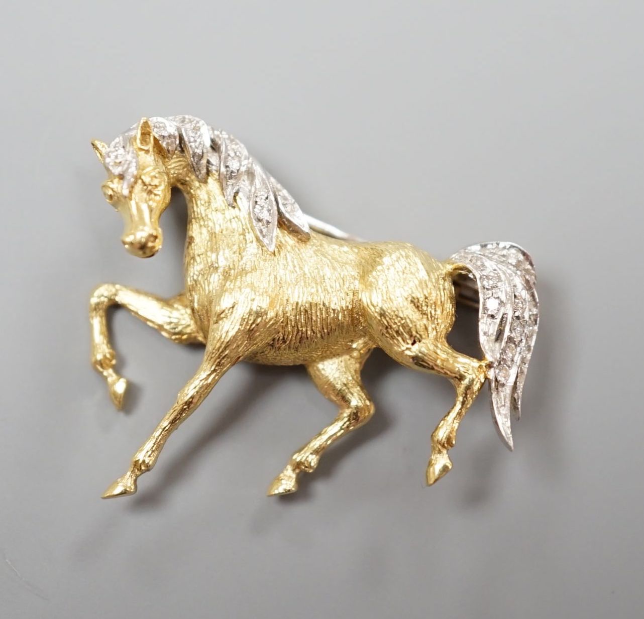 A modern 18ct gold and diamond chip set horse brooch, 29mm, gross weight 7.4 grams.